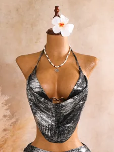 Detailansicht des schwarzen Bikini-Tops mit Goldfolie, Wasserfallausschnitt und Metallring.