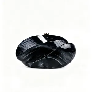 Detailed view of the black and white wave acrylic clutch bag texture and metal clasp design.