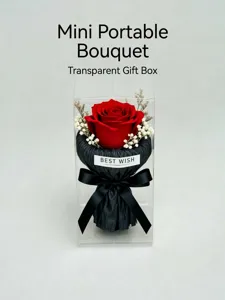 Detailed close-up of a miniature preserved red rose bouquet in a clear box with black bow.