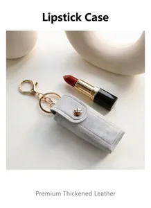 Dettaglio ravvicinato della mini custodia in pelle per rossetto con portachiavi e fibbia.