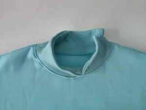 Close-up detail of the women's fleece-lined turtleneck sweatshirt, soft blue rib knit collar.
