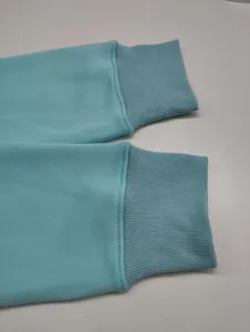 Close-up detail of women's sweatshirt sleeve cuffs in light blue, ribbed knit texture.