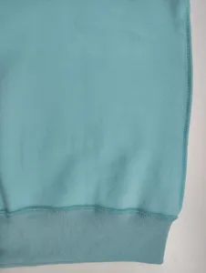 Close up view of women fleece sweatshirt hem, soft blue fabric detail and ribbed cuffs.