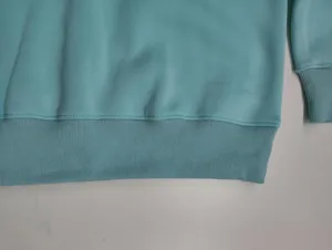 Close-up detail of the casual women fleece sweatshirt hem and ribbed cuffs in light blue.