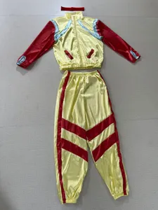 Details van het 80s retro disco trainingspak, met opvallend geel en rood ontwerp.