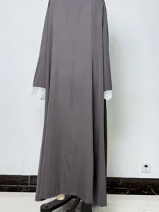 Detailansicht des grauen weiten Maxikleid-Ärmels mit zarter weißer Spitzenborte, langer Umhang.