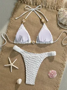White textured bikini detail showing shell beads and straps. Perfect summer swimwear design.