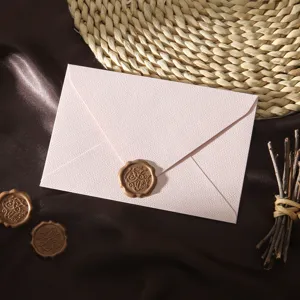 Nahaufnahme eines rosafarbenen strukturierten Umschlags mit Siegel, elegantes Vintage-Detail.