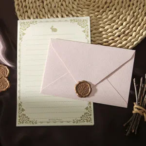 Vintage stationery set with pink textured envelope, letter paper and wax seal stamp.