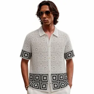 Detailed view of men's black and white contrast crochet knit polo shirt cardigan with pattern.