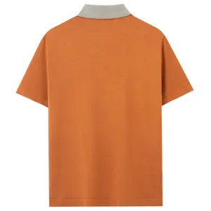 Back view detail of the orange knit short sleeve polo shirt featuring a ribbed grey collar.