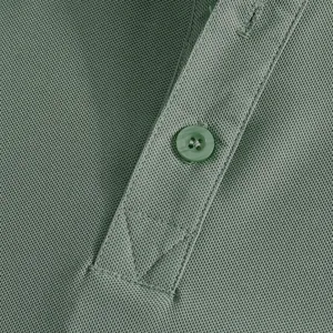 Close-up detail of green polo shirt fabric, button placket, and fine stitching quality.
