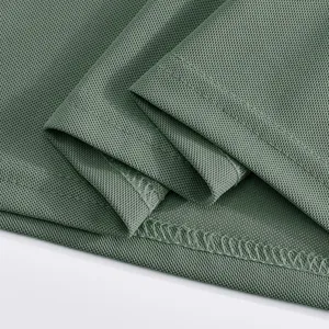 Close-up view of green breathable mesh fabric detail, showing fine stitching and texture.