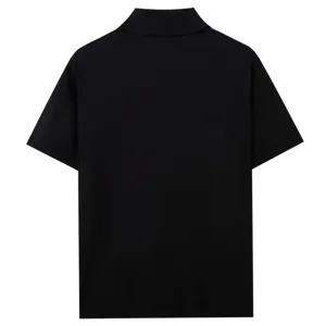 Vue détaillée du polo en tricot noir montrant la texture du col et les finitions du dos.