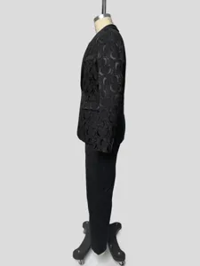 Dettaglio della vista laterale di un abito nero in jacquard con motivo floreale.