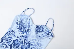 Closeup of blue and white abstract print slip dress featuring slim straps and low-cut design.
