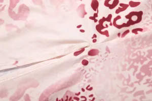 Detail view of the stylish pink abstract print dress fabric, showing fine stitching and texture.