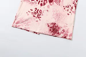 Detailed close-up shot of women dress lower hem featuring pink red abstract leopard print design.