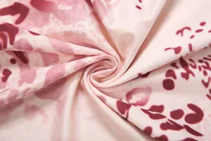 Close up view of the women's summer casual dress fabric with abstract floral pink print.