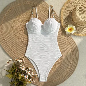 Elegante costume intero bianco con coppe a conchiglia e spalline con perline.