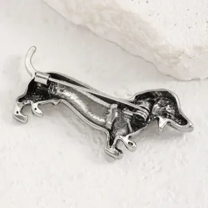 Broche épingle chien teckel argenté vintage, détail de bijoux animal en métal fin.
