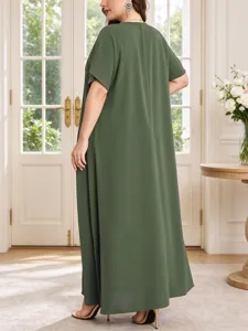 Detail view of a loose dark green summer plus size maxi dress worn by a model indoors.