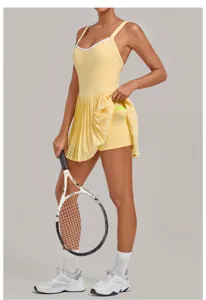 Yellow athletic tennis dress featuring pleated skirt, built-in shorts and stylish backless design.