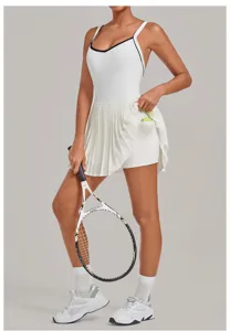 White backless pleated tennis dress detail view, featuring built-in shorts and side pocket.
