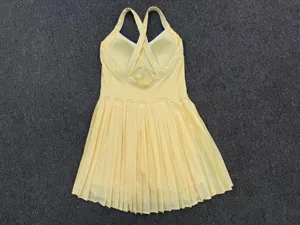Yellow activewear tennis dress with backless cross straps and pleated skirt for fitness sports.
