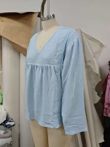 Hellblaues Langarmshirt Detail mit V-Ausschnitt, zarter Spitzenborte und geraffter Taille.