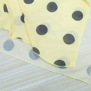 Detailed view of yellow polka dot sheer mesh skirt fabric showcasing layered design.