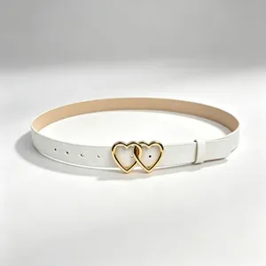 Elegant white PU leather belt detail with shiny gold double heart buckle for stylish women.
