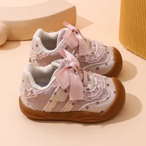 Vista di dettaglio scarpe primi passi bambina rosa a pois con suola morbida fiocco.