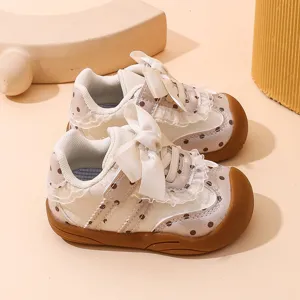 Scarpe primi passi bambina suola morbida con pois, pizzo e grazioso fiocco bianco.