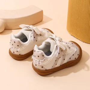 Scarpe morbide per bambina con pois, volant in pizzo e delizioso fiocco decorativo.