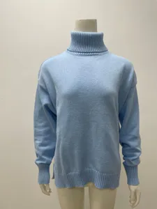 Détail de pull col roulé bleu clair, tissu en maille ample, ourlet fendu sur le côté.