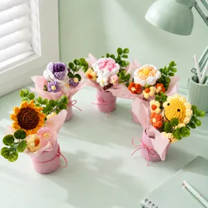 Handmade crochet flower bouquet placed in a pink gift bucket, detailed desk decor view.