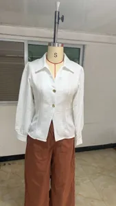 Detailed view of white long sleeve blouse featuring lapel collar and golden metal buttons.
