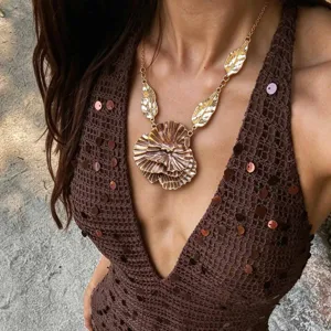 Exquisite metallic flower and leaf pendant necklace detail view, statement jewelry accessory.