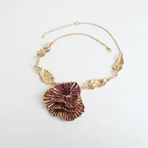 Detailed view of the statement metallic floral pendant necklace with unique red ruffled petals.
