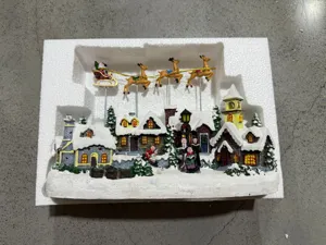 Christmas resin snow village music box with flying reindeer and Santa Claus ornament for holiday.