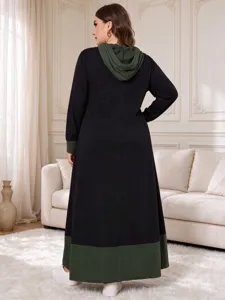 Detailed view of the elegant color-block hooded long dress showcased in a cozy interior setting.