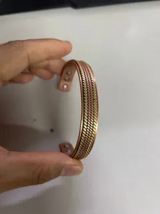 Close-up of copper magnetic therapy bracelet featuring wheat braid design and open cuff.