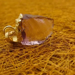 Pendentif en améthyste brute naturelle avec bordure plaquée or, bijou en pierre unique.