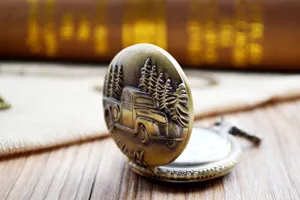 Retro bronze pocket watch detail shot, antique truck and pine tree relief design.