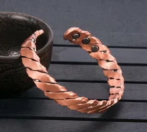Primo piano che mostra il raffinato design intrecciato e la texture in rame del bracciale.