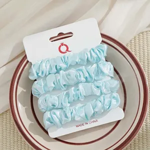 Lichtblauwe satijn haarelastiekset op kaart, elegante haaraccessoires voor vrouwen en meisjes.
