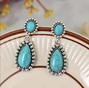 Close-up detail view of vintage style silver plated turquoise drop earrings with teardrop stone.