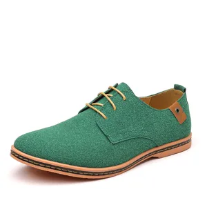 Closeup of green suede casual lace-up men shoe with brown outsole and textured design.