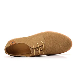 Detail view of men's brown suede casual lace-up shoe showing texture and heel badge.